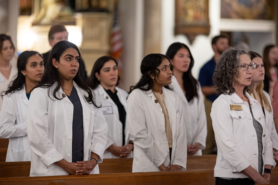 professionals in white coats in pews